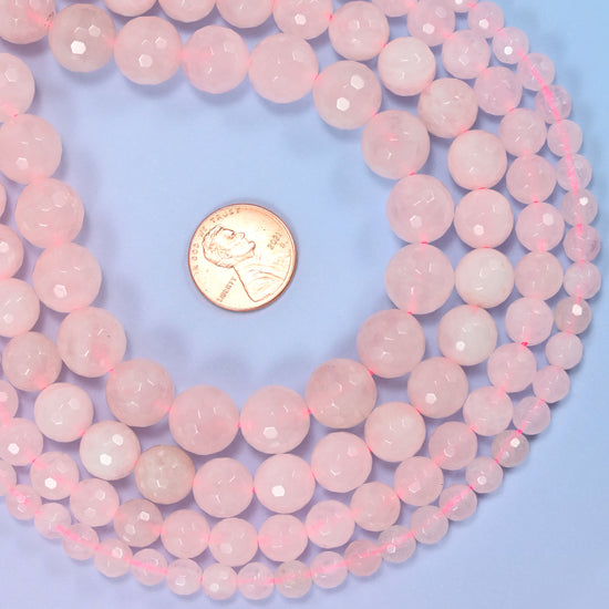 Group of pink rose quartz round beads showing natural color and pattern variation.
