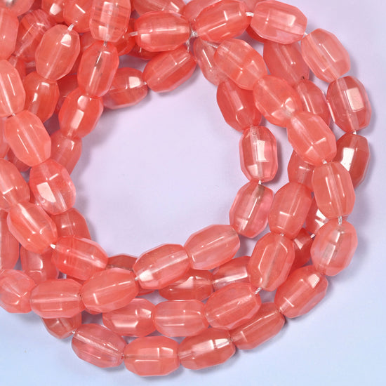 Close-up circular coil of faceted glass barrel bead strands with a penny in the center for size comparison.