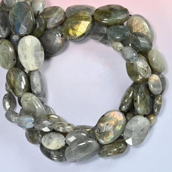 Gray Labradorite faceted oval beads coiled into a ring, one bead showing a full gold flash