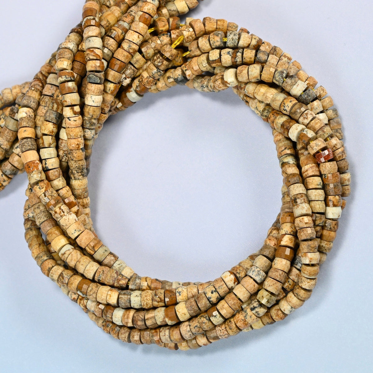 Picture jasper faceted heishi disc beads coiled into overlapping loops, whole strands of warm tan stone