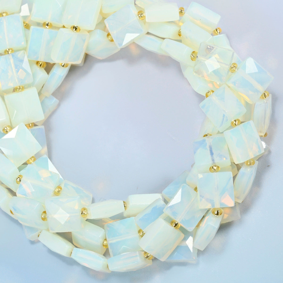 Opalite faceted flat square beads coiled into overlapping loops, whole strands of milky white glass