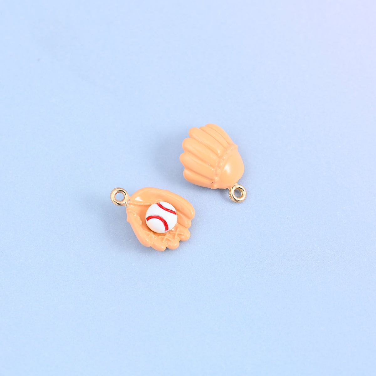 Two light orange baseball glove charms, front and back, showing the raised laces on the glove.