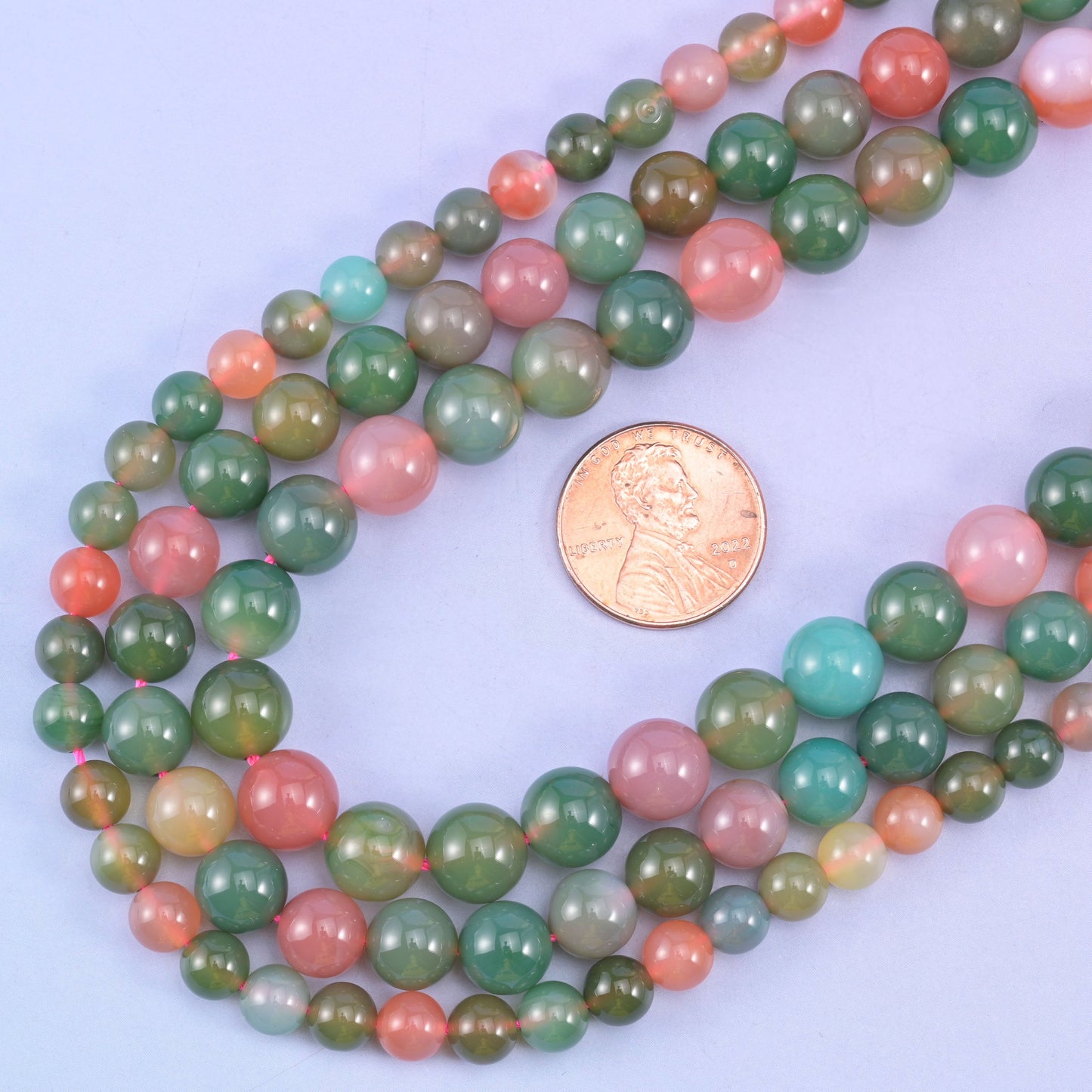Green Yanyuan Agate round beads with a US penny alongside for size reference, sold per 14 inch strand