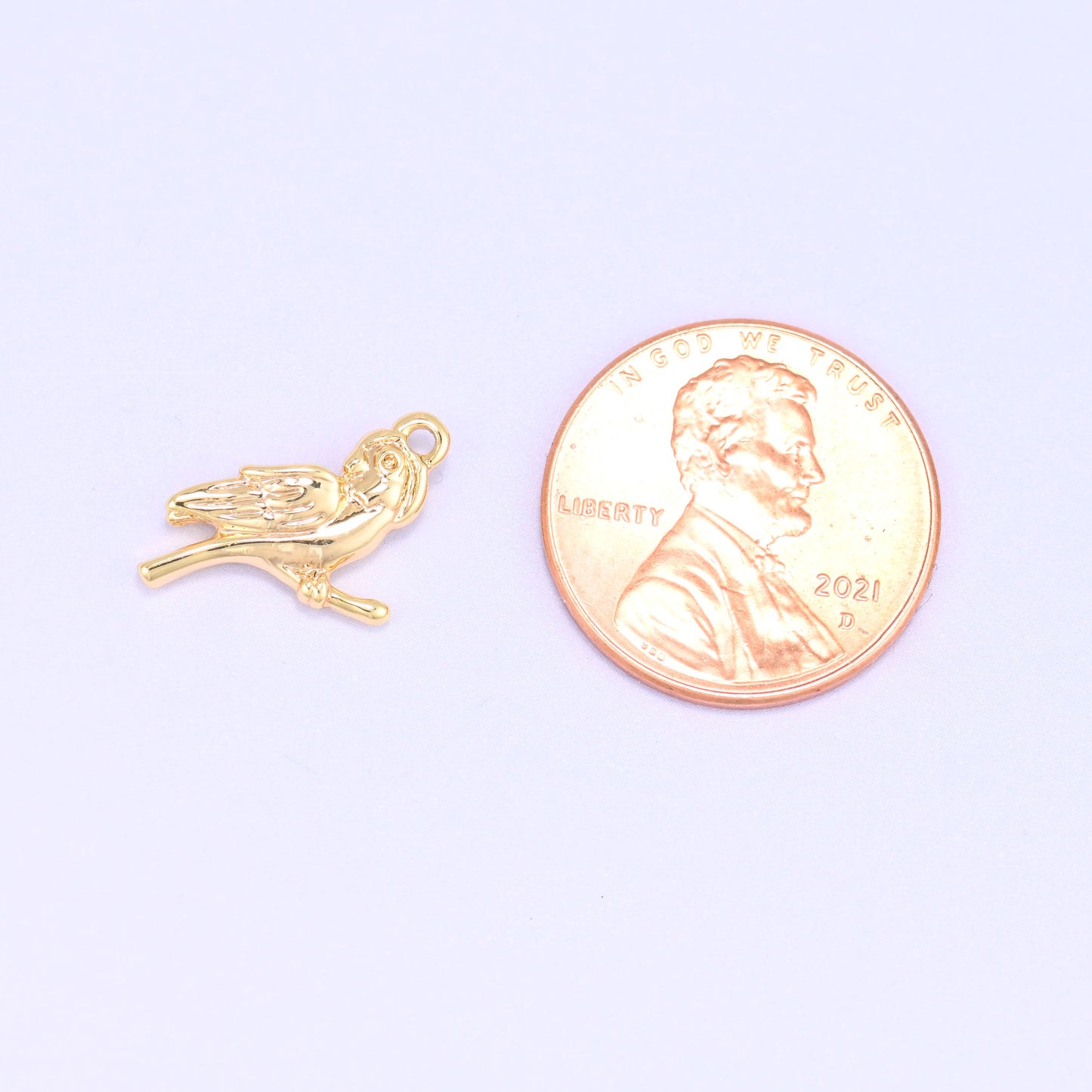 Small gold charms bird shown beside a US penny for scale, 18K gold plated 15.9x9.1mm charm