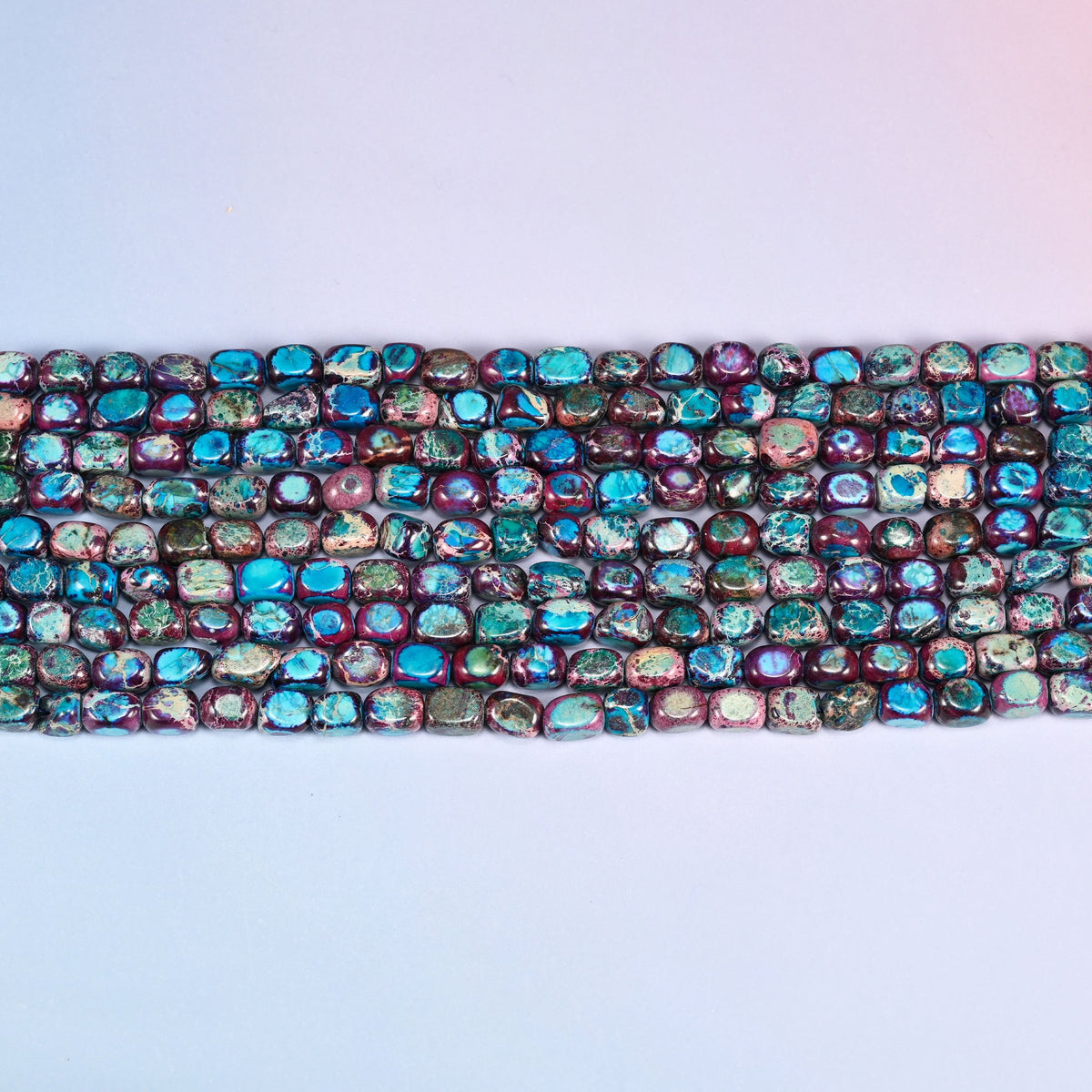 Dyed sea sediment jasper nuggets with dark mineral veining and a glossy polish.