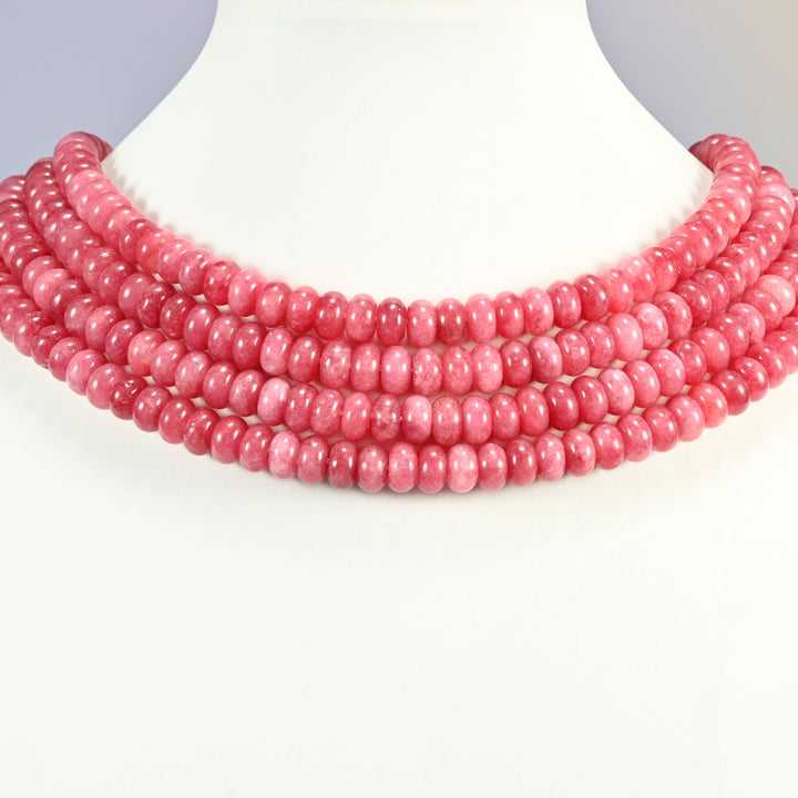 Raspberry Red dyed jade gemstone rondelle beads shown on a display bust as a layered collar, several strands stepping down in a row