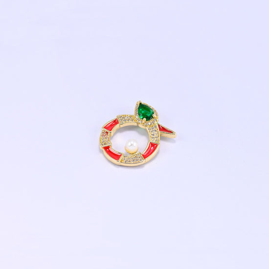 Single round snake charm on lavender, the coiled gold body banded in red enamel and clear zircon with a small pearl set inside the ring.