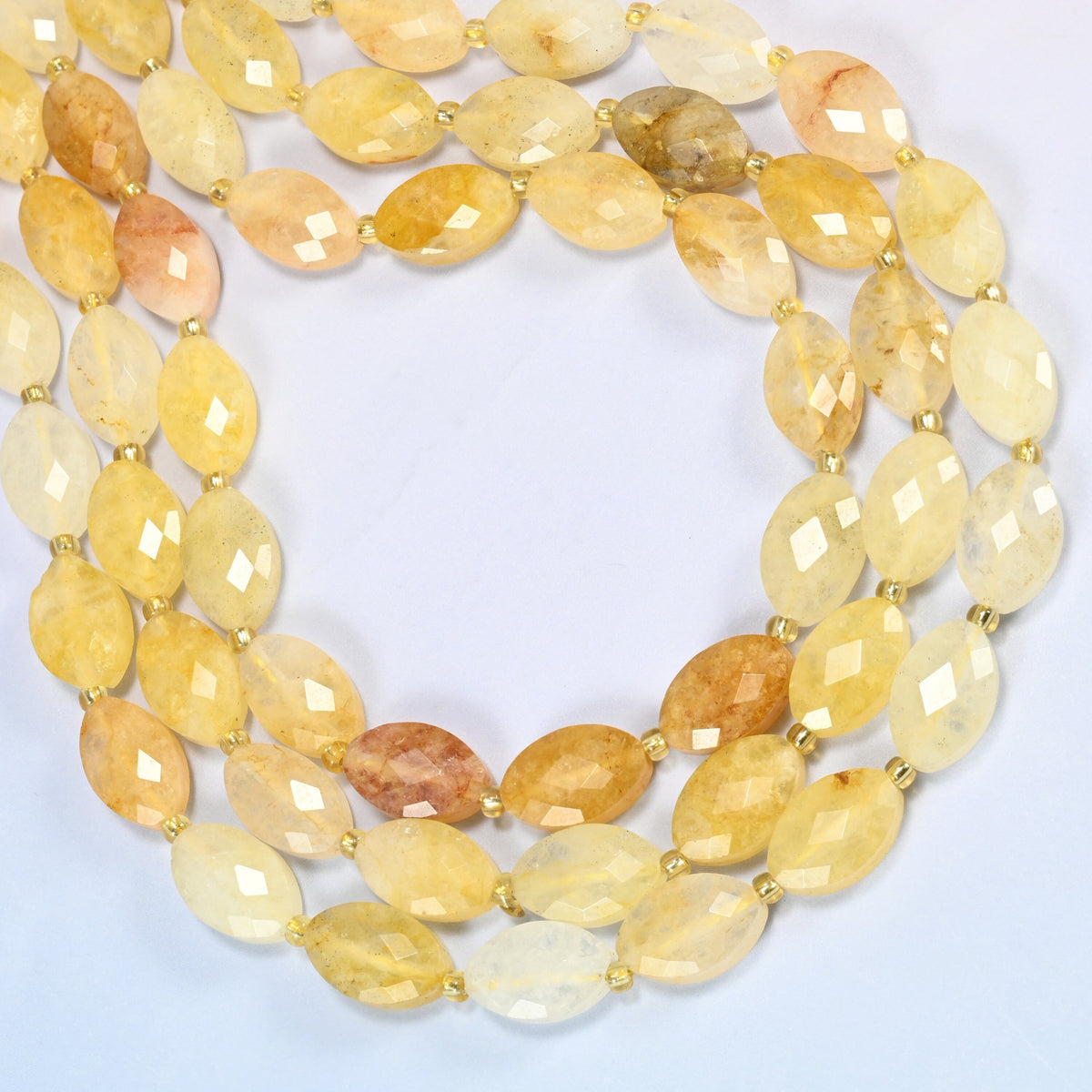 Golden healer quartz faceted flat oval beads curved into an open loop, golden yellow, honey and cream beads