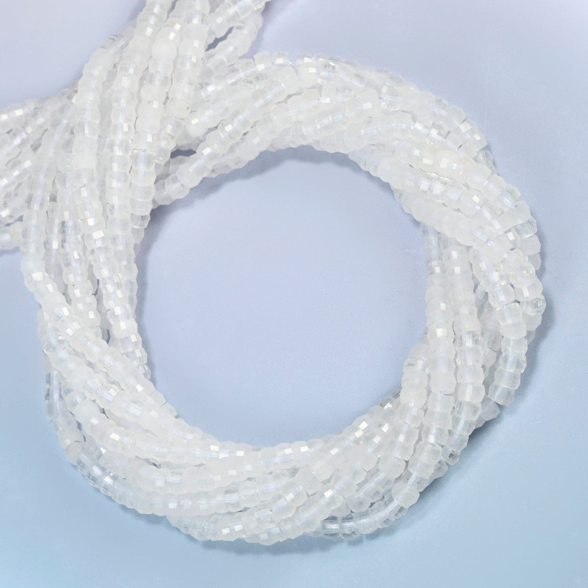 Clear quartz faceted heishi disc beads coiled into overlapping loops, whole strands of clear sparkling stone