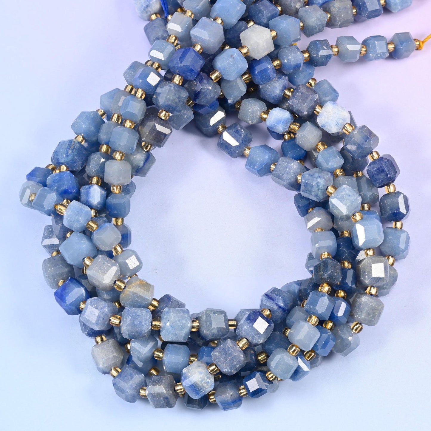 Soft denim and steel blue cubes clouded with chalky grey-white, the surface reading closer to frosted than glossy while the cut corners still throw small bright flashes.