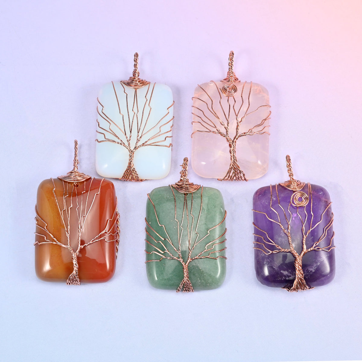 Five colour options of the Rectangle Gemstone Tree of Life Pendant arranged as a flat-lay: white, blush pink, red-orange, green and purple.