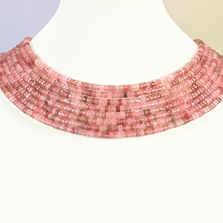 Strawberry quartz faceted heishi disc strands arranged as a layered collar on a white display bust, pink beads across the neck