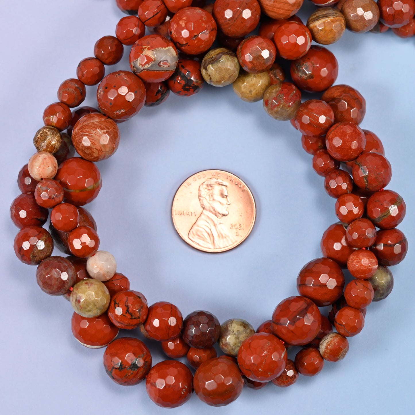 Close-up of flower red jasper round beads, showing the faceted finish and natural red tone.