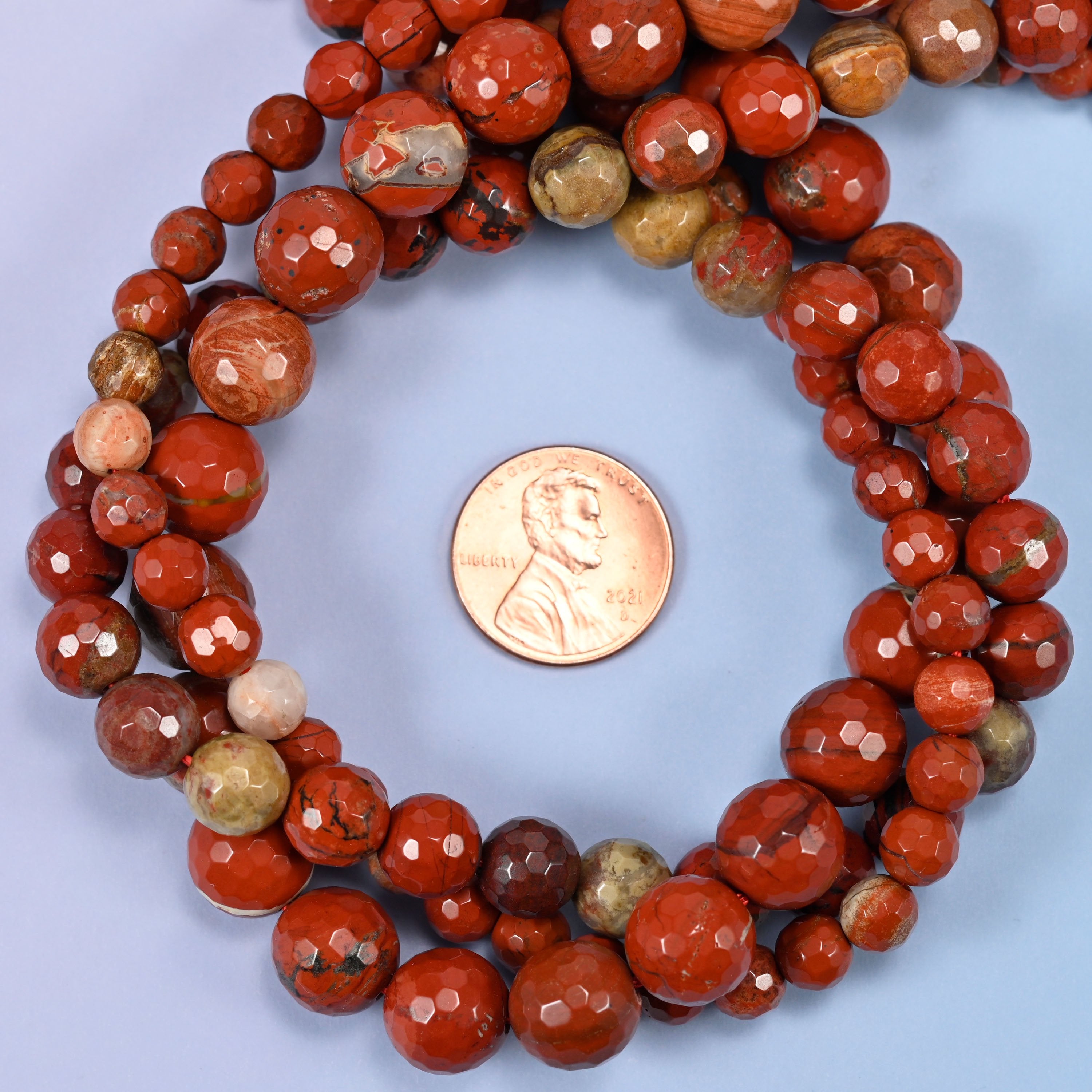 Close-up of flower red jasper round beads, showing the faceted finish and natural red tone.