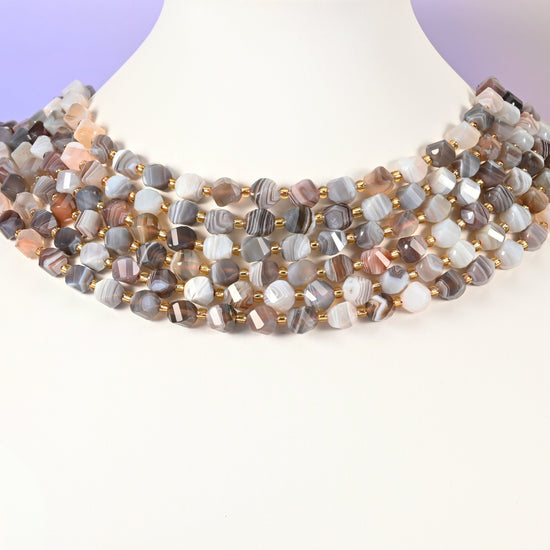 Botswana agate natural stone beads showing fine parallel banding in grey, white and cream across the 8mm faceted beads