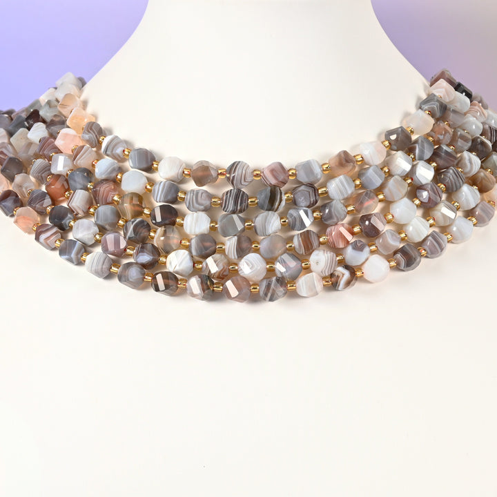 Botswana agate natural stone beads showing fine parallel banding in grey, white and cream across the 8mm faceted beads