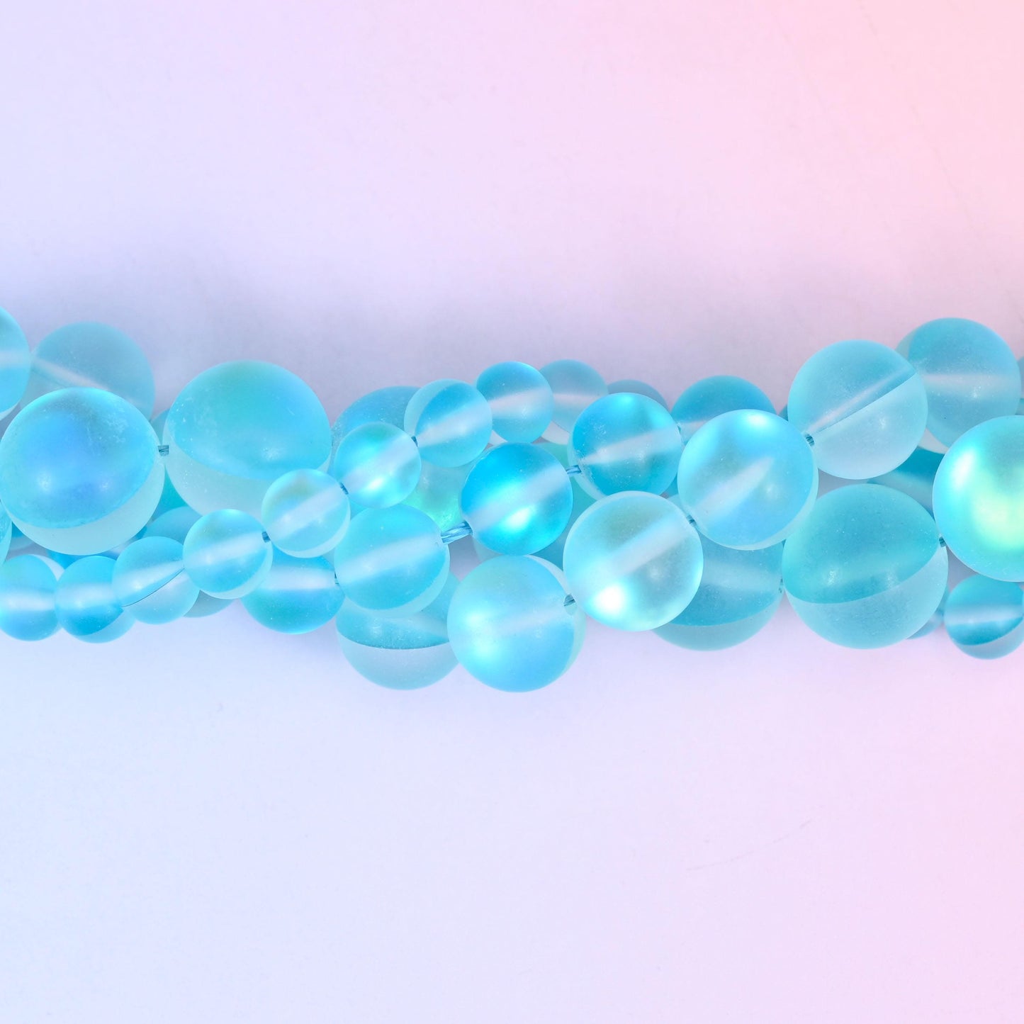 Bright aqua glass beads with a sanded frosted finish and aurora glow