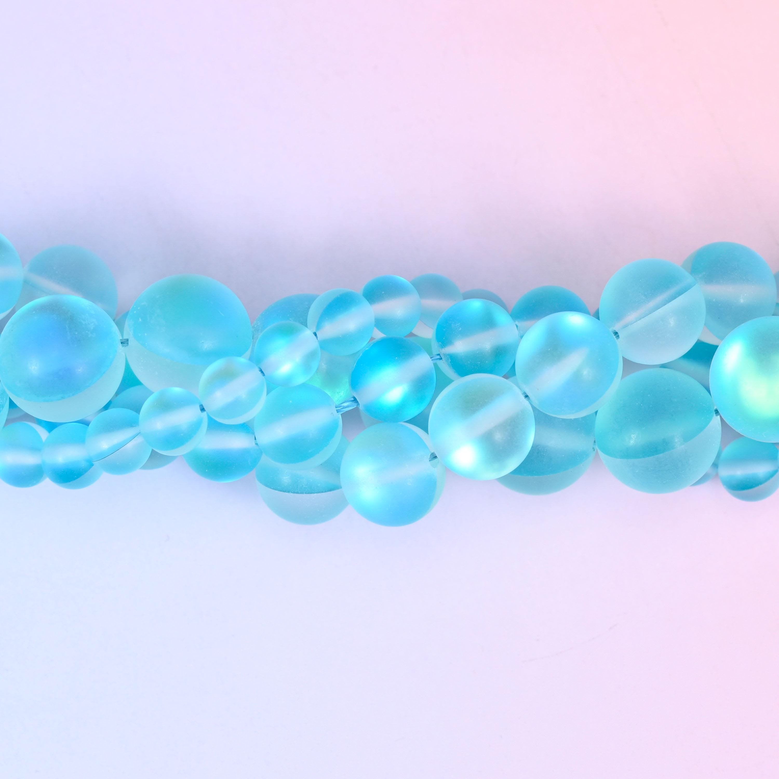 Bright aqua glass beads with a sanded frosted finish and aurora glow