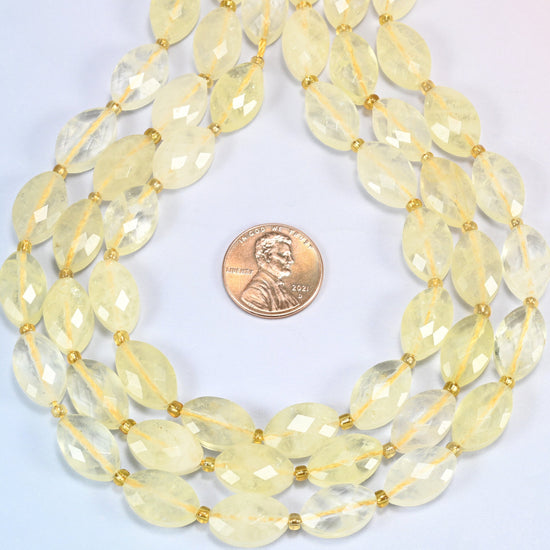 Citrine faceted flat oval strands formed into a teardrop loop around a US penny for scale