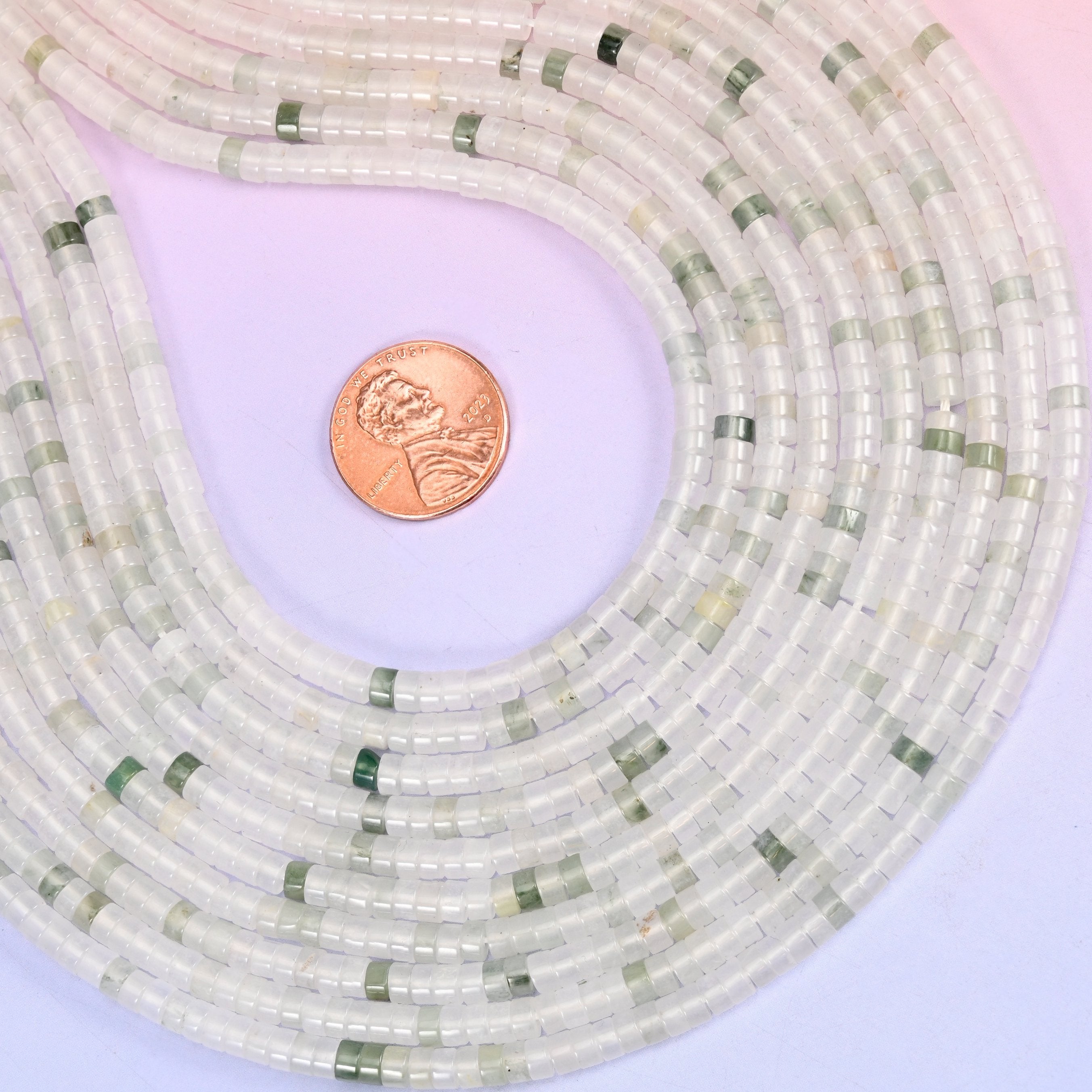 Natural Tianshan Jade smooth heishi disc beads in soft milky white with scattered sage-green accents, finished with a polished, sophisticated look.