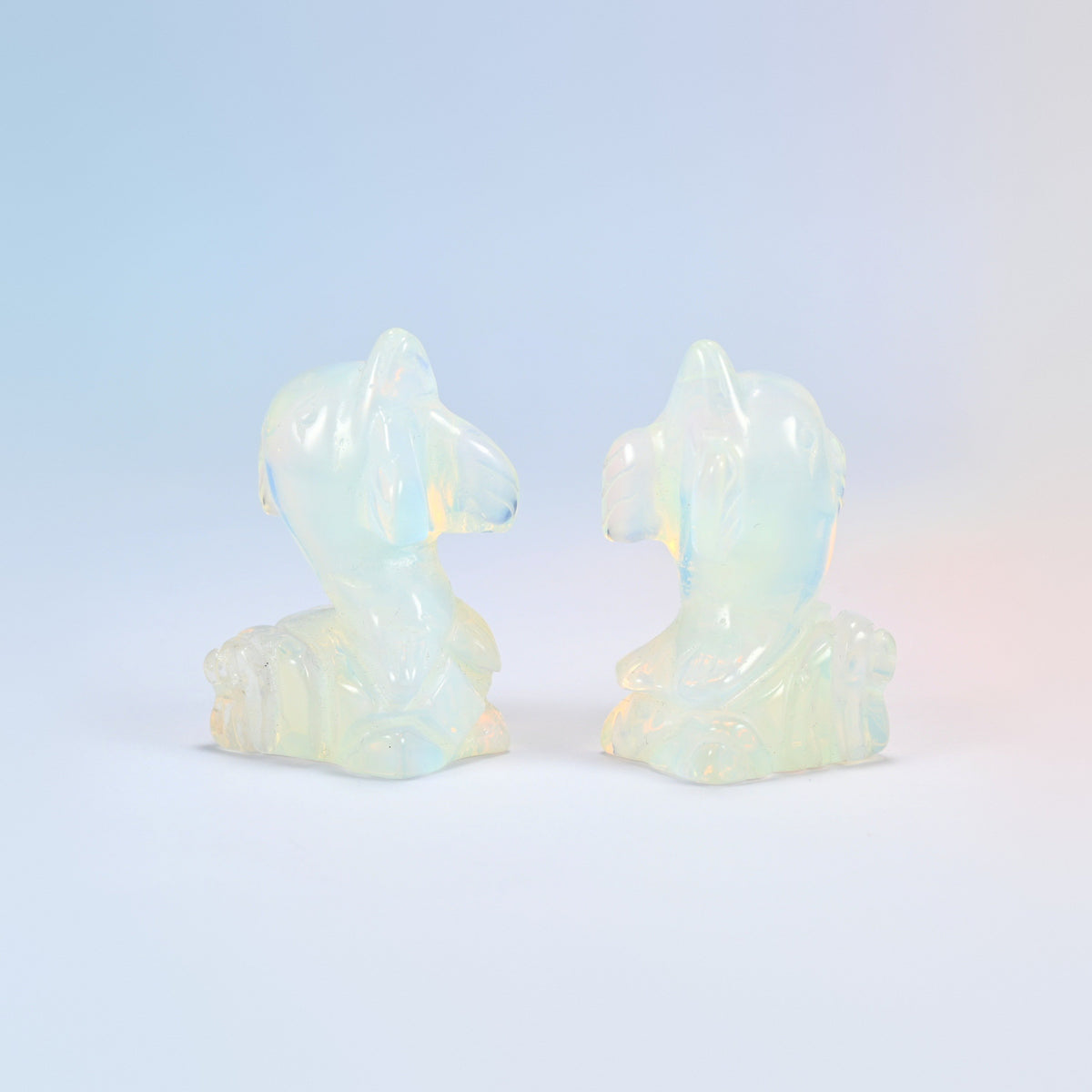 Two opalite dolphin carvings side by side, 2 inch, milky white with blue shimmer