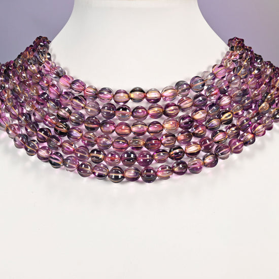 Pink blue gold pumpkin glass beads arranged as a layered collar, the 16 inch strands curving in even rows.
