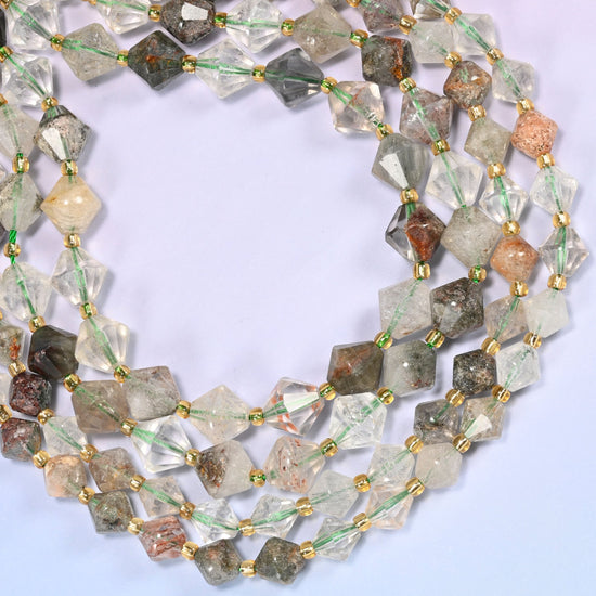 Green Phantom Quartz faceted bicone beads, 8mm and 10mm, coiled into a loose circle on a light lavender background.