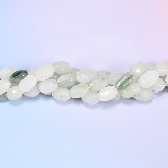 Close-up horizontal row of Tianshan Jade faceted barrel beads laid straight, showing the polished facet detail up close.