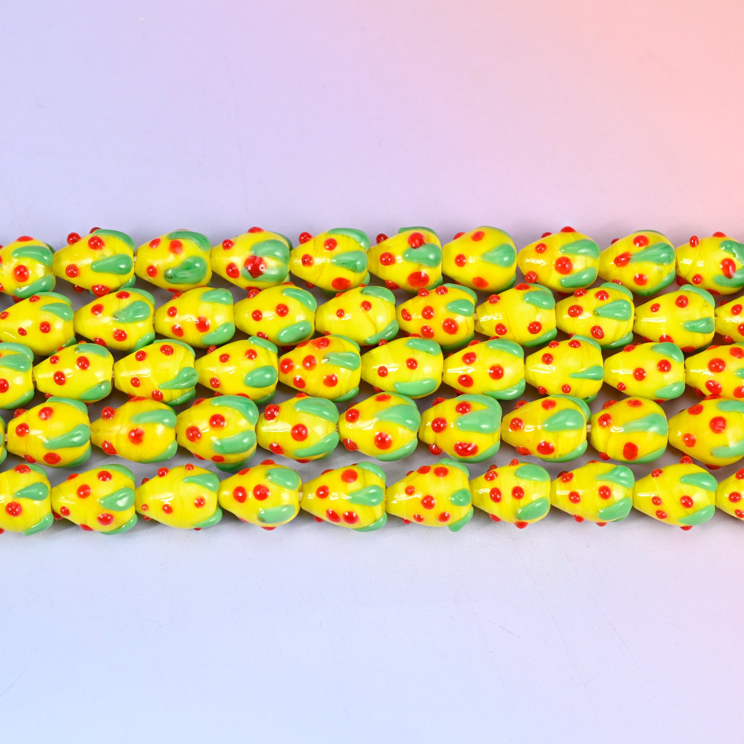 Yellow Red Dots Strawberry Glass Beads in sunny opaque yellow with a green leaf cap