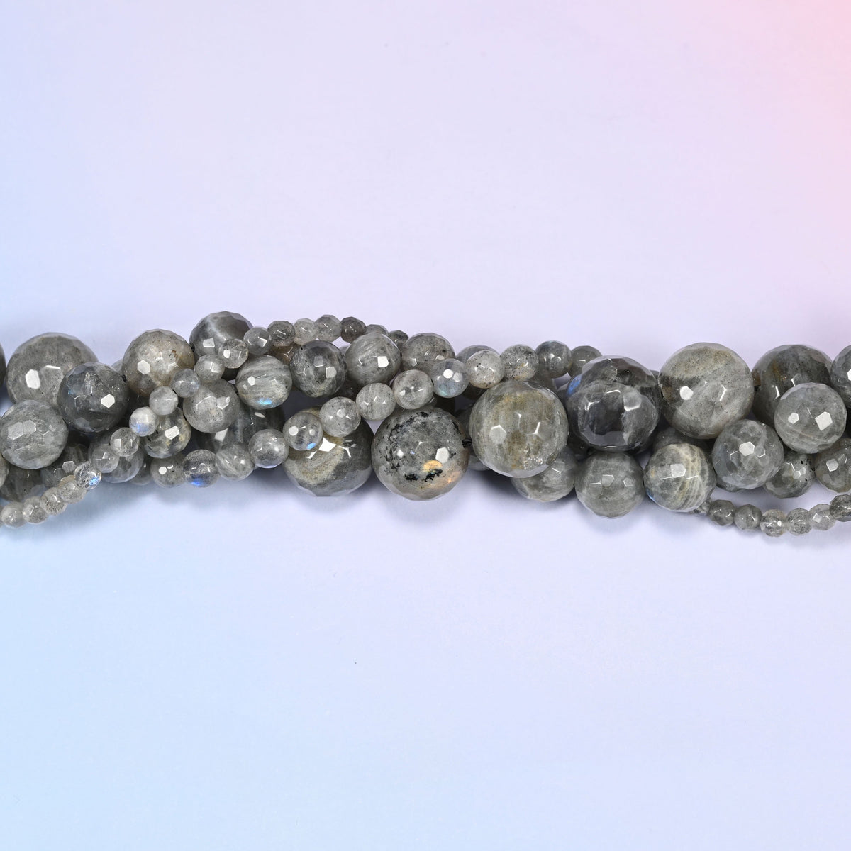Gray Labradorite faceted round beads in a single close run, the many small flat planes visible on each bead