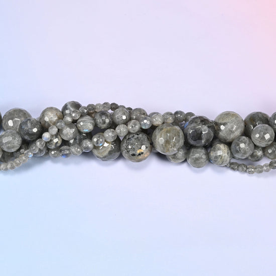 Gray Labradorite faceted round beads in a single close run, the many small flat planes visible on each bead