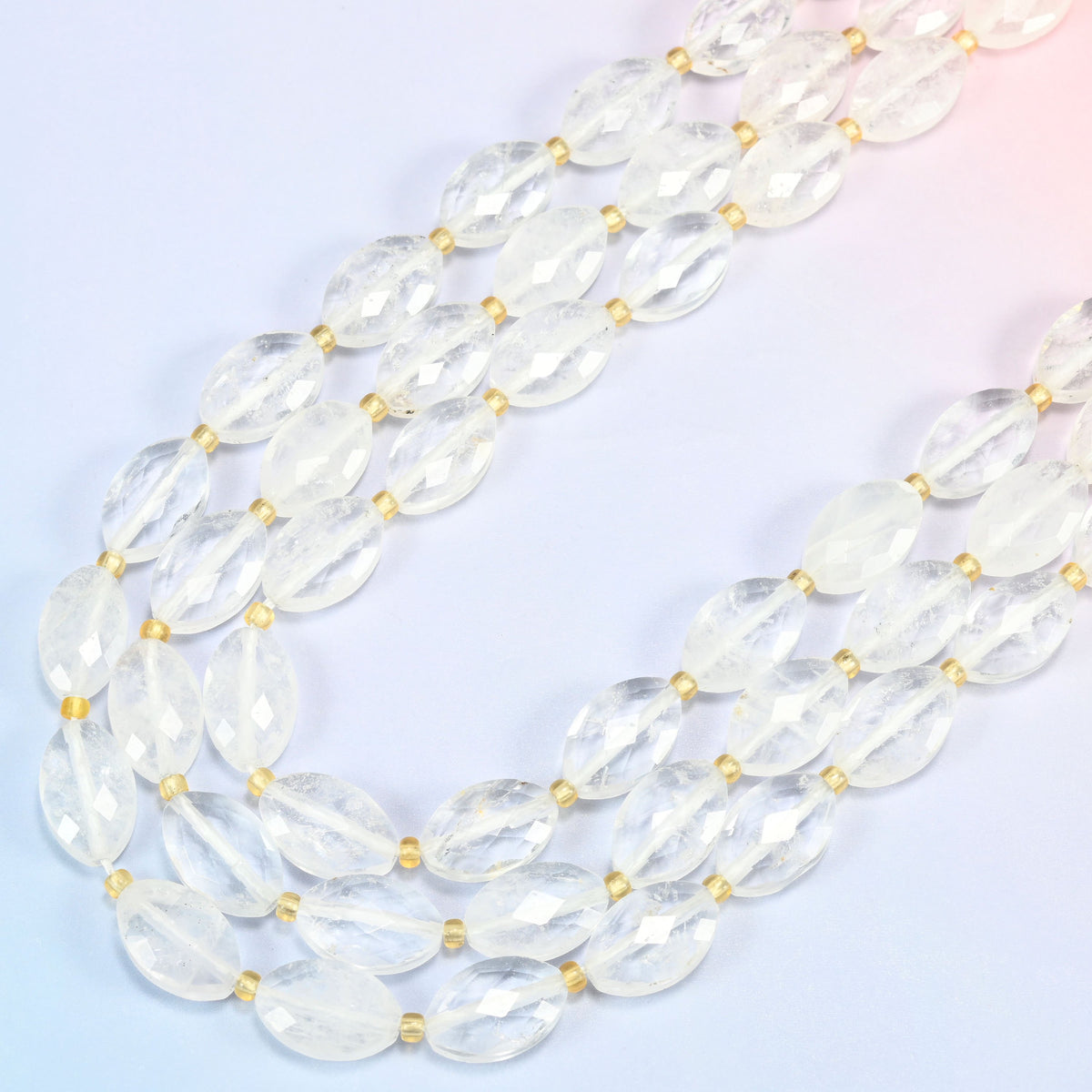 Clear quartz faceted flat oval beads in several strands curved into a wide U, water-clear quartz