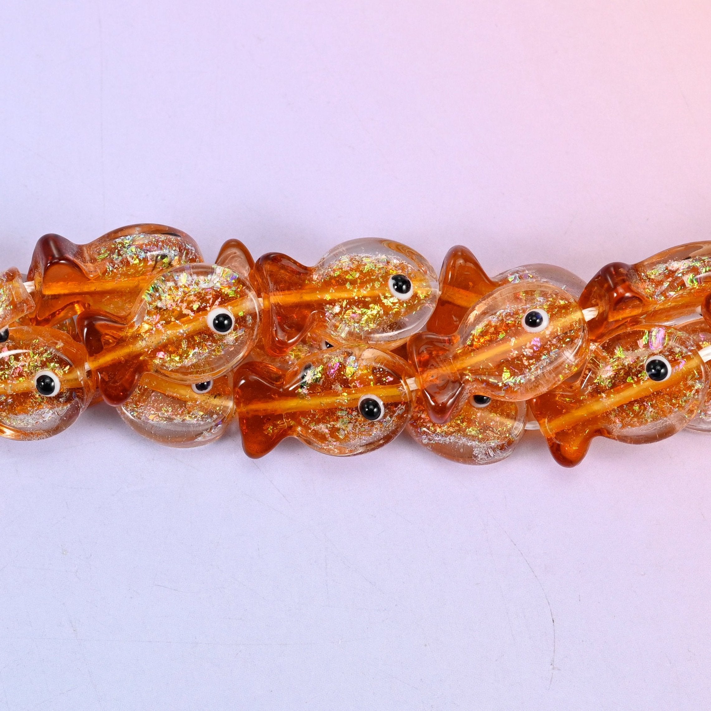 Fish shaped orange glitter glass beads