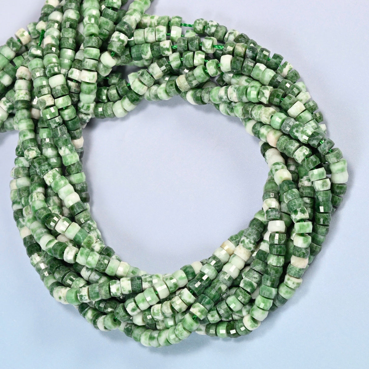 Tree agate faceted heishi disc beads coiled into overlapping loops, whole strands of green and white stone
