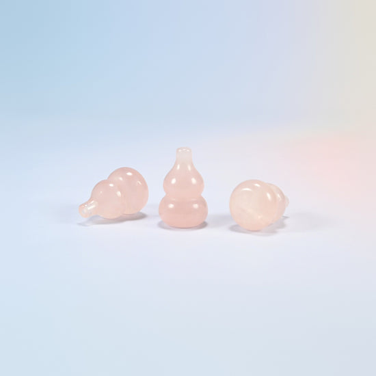 Natural rose quartz gourd carvings, one standing and two lying on their sides