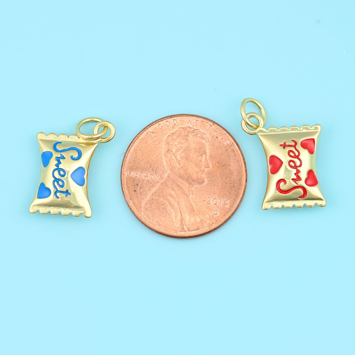 16mm enamel sweet candy charms either side of a US penny, both charms smaller than the coin.