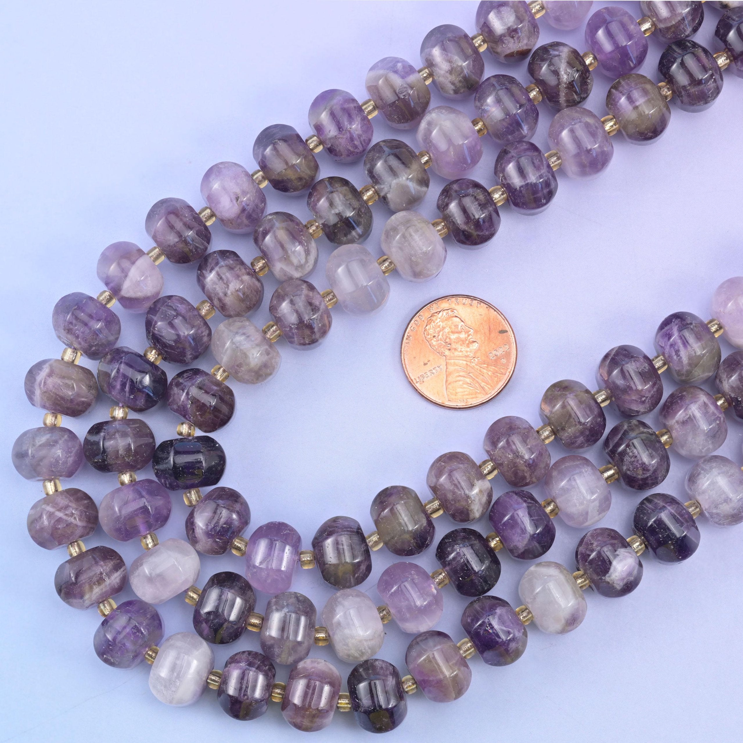 US penny resting inside the loop of the strands, giving true scale for the 12x8mm beads