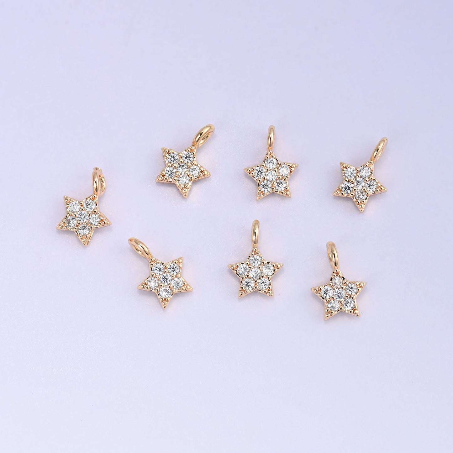 Small gold charms, eight gold plated star charms arranged in two rows
