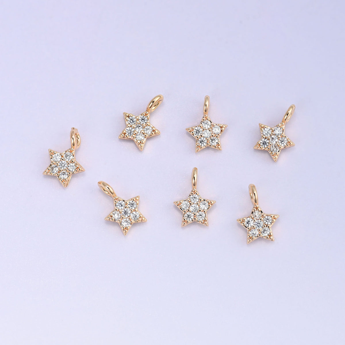 Small gold charms, eight gold plated star charms arranged in two rows