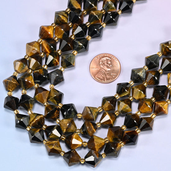 Close-up of 10mm Iron Tiger Eye faceted bicone beads in a loose curved strand, showing the faceted cut and gold-tone spacer beads.