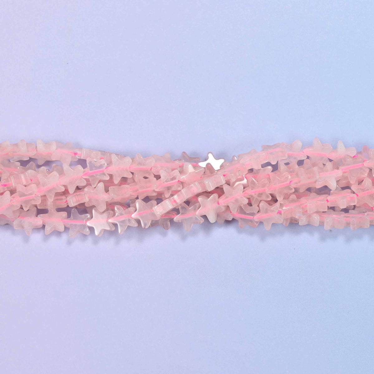 Rose quartz flat star beads in pale milky blush, cut into little flat five-pointed stars.
