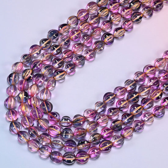 Pink blue gold pumpkin glass beads laid in a narrow chevron, the two limbs running close together down to a point.