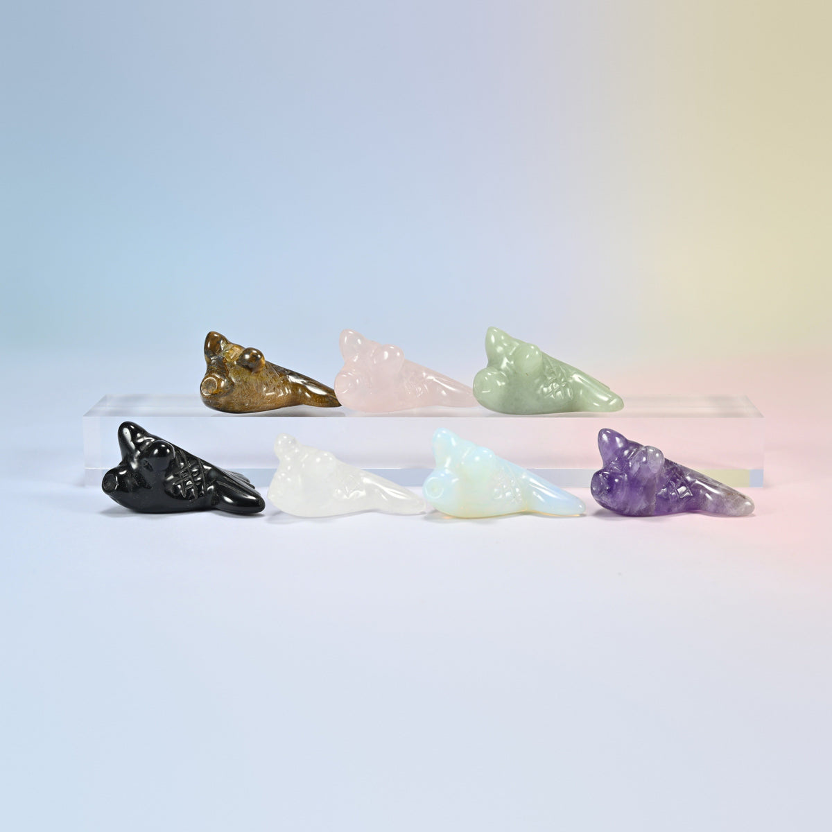 Seven 1.5 inch goldfish crystal carvings in natural tiger eye, rose quartz, green aventurine, black obsidian, clear quartz, amethyst and opalite