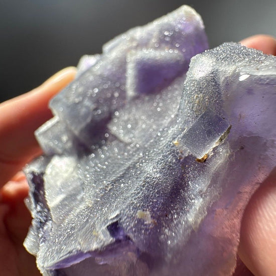 Side of the piece showing deep violet edges under a heavy sugary quartz layer