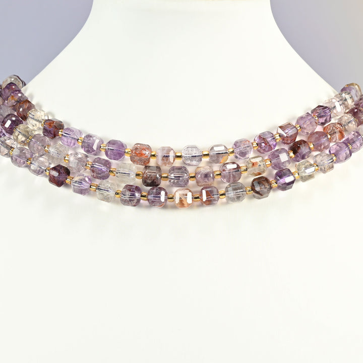 Natural Super 7 faceted cube strands layered as a collar on a white display bust, light purple and clear stone across the neck