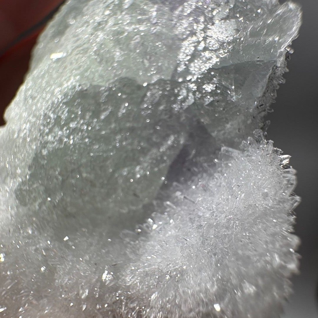 Close view of the sparkling sugary quartz druzy where it meets the translucent green fluorite