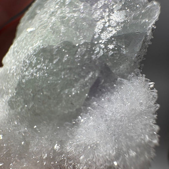 Close view of the sparkling sugary quartz druzy where it meets the translucent green fluorite