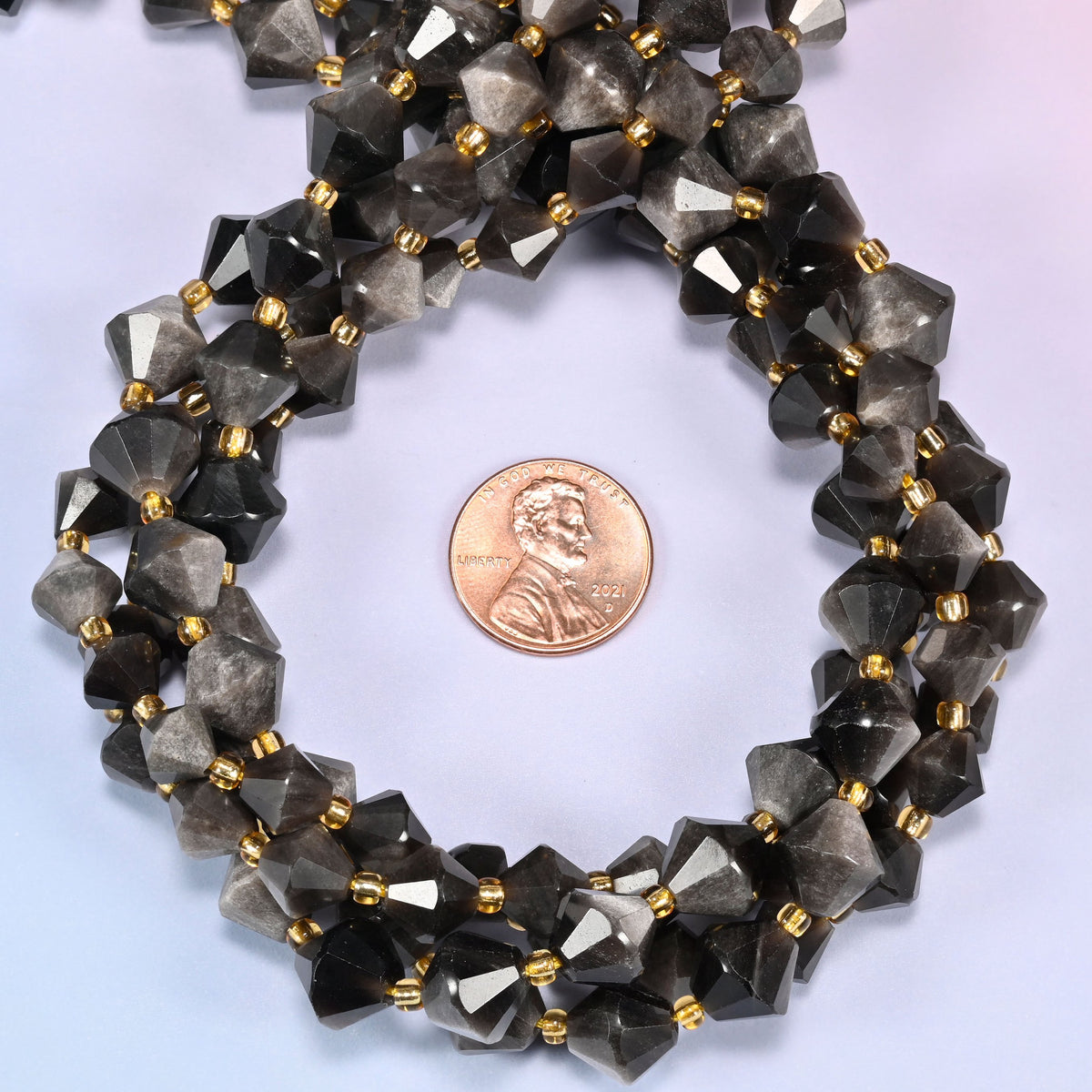 Silver obsidian bicone beads coiled into a round ring, 8mm and 10mm sizes available, gold-tone spacers throughout.