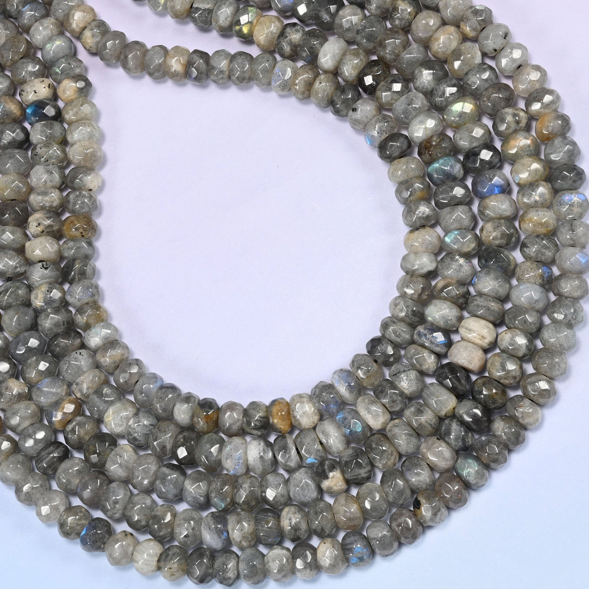 Gray Labradorite faceted rondelle beads curved into a wide open loop, blue flash catching along the cut edges
