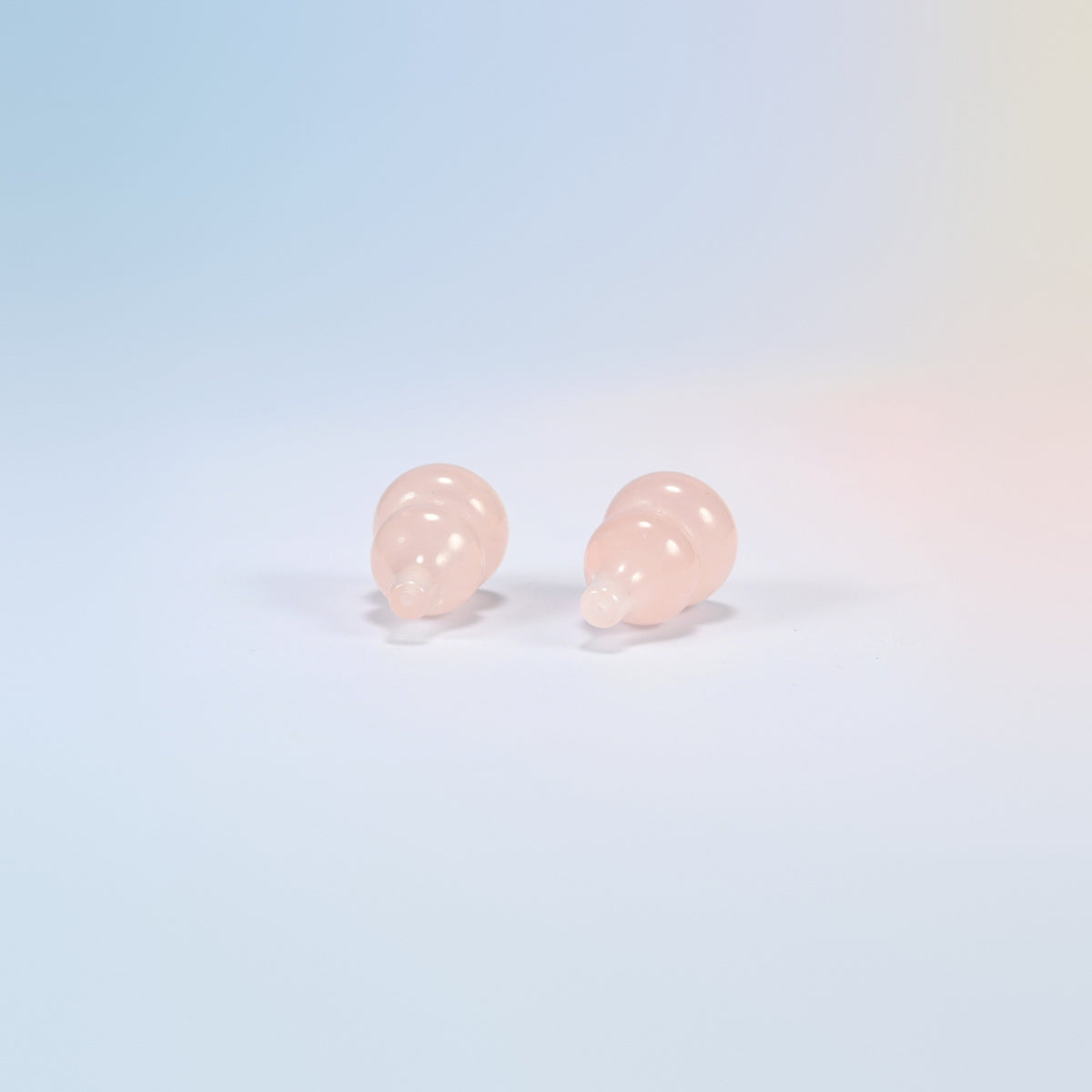 Top view of two natural rose quartz gourds showing the carved stem